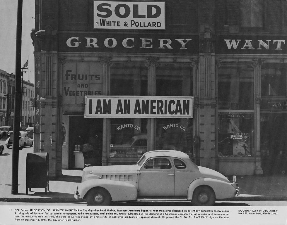 December 8, 1941: Tatsuro Matsuda installs the “I AM AN AMERICAN” sign on his Oakland business. Despite this, the Matsudas were forced to close Wanto Co. months later after being incarcerated under Executive Order 9066 along with 120,000 other Japanese and Japanese Americans. Photo by Dorothea Lange
