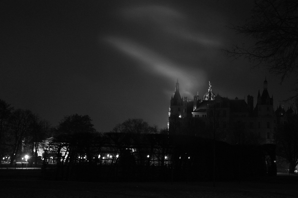 Castle at night with beams of light in the sky