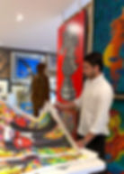 Contemporary artist viewing vibrant pop art in a studio