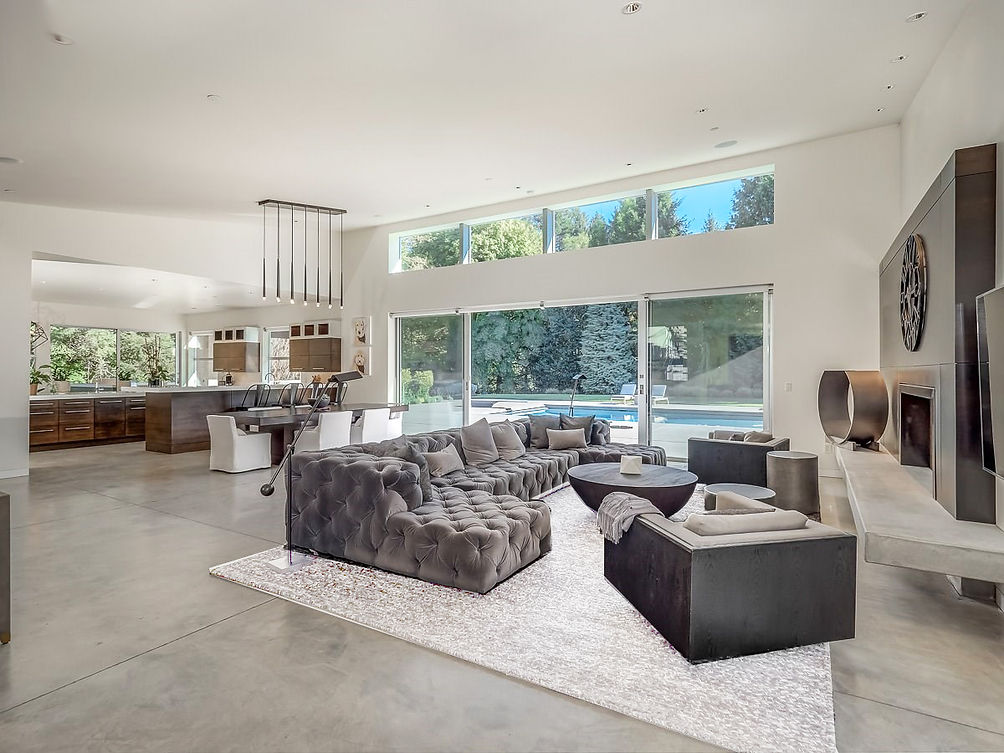 gray tufted couch, sectional couch, gray tweed rug, poured cement floor, modern pendant lighting, modern coffee table, round coffee table, upholstered side chairs, wood kitchen cabinets, modern interiors hamptons, upholstered dining chairs s