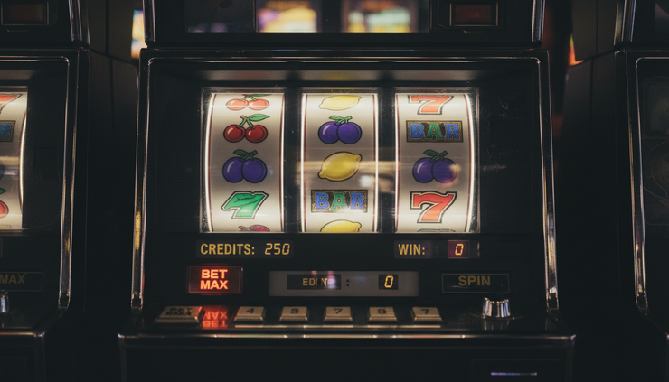 Close-up view of a glowing slot machine screen in a dim arcade with no brand names visible.