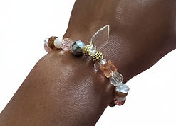 Handmade beaded bracelet with clear and peach beads, worn on a wrist