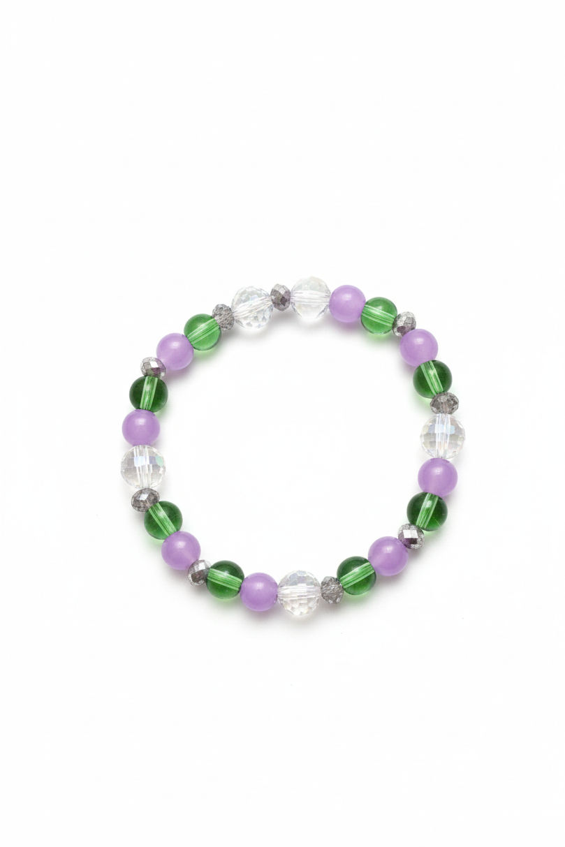 A beaded stretch bracelet with an alternating pattern of lavender purple, translucent green, and faceted clear crystal beads, shown on a solid white background.