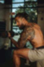 ein Mann der Kurzhantelcurls macht.