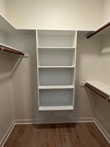 Spacious walk-in closet with custom shelving and organization in modern farmhouse.