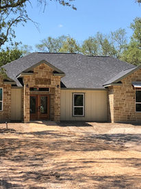 Modern farmhouse exterior with large windows and a welcoming front entry way.
