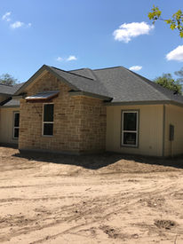 Modern farmhouse exterior with large windows and a welcoming front entry way.