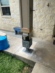 Renovated pavilion with columns wrapped in metal and covered with stone, replacing old rotten wood posts. 