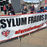 Banner saying "Asylum Frauds Out" at AFFG's rally on 6-9-25