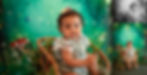 Baby in lace outfit sits on a bamboo chair in a whimsical forest scene with mushrooms and twinkling lights, creating a magical atmosphere as photographed by Tiffany Edwards, Newborn Photographer in Billings, Montana.