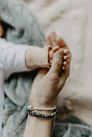 Sanfte Berührung: Eine Hand hält liebevoll die kleine Hand eines Babys – Symbol für Geborgenheit in der Babymassage