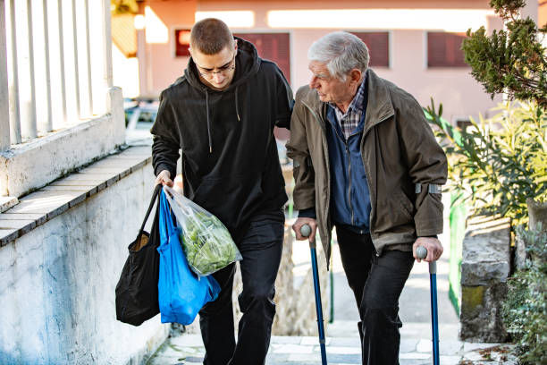 Young man helping an old man with his groceries
