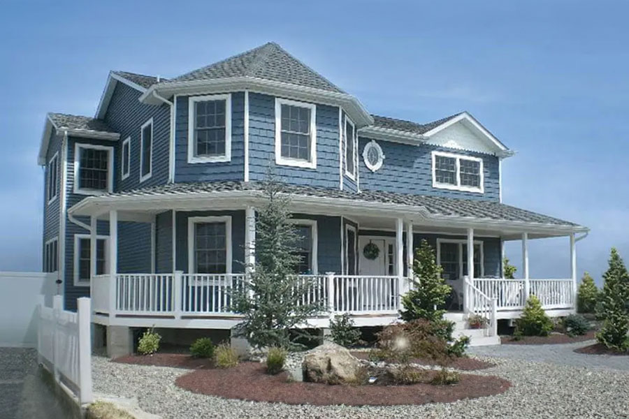Custom modular house exterior featuring a classic front porch and blue clapboard siding.