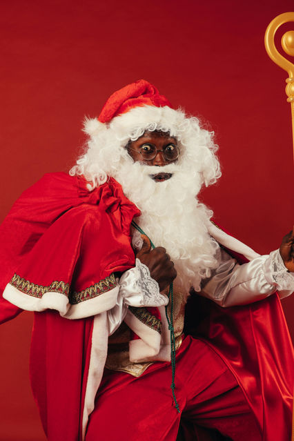 Man of color dressed in Santa regalia with eyes wide