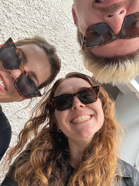 Team mit Sonnenbrillen, lächeln in die Kamera