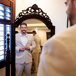 Groom getting ready while looking in mirror at Harbour House in Florida. Photo by Pixel Groves