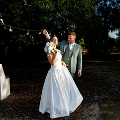 Bride and groom standing outdoors at night with dramatic lighting and bride holding bouquet