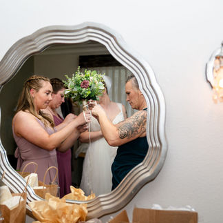 Brides mother and bridesmaids tying ribbon on bouquet before wedding at Harbour House in Florida. Photo by Pixel Groves