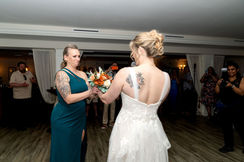 Bride giving her mom her bouquet during reception at Harbour House in Florida. Photo by Pixel Groves