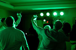 Wedding guests lit up by DJ lights during wedding reception at Harbour House in Florida. Photo by Pixel Groves