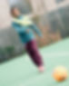 A happy young football player walks across a football pitch