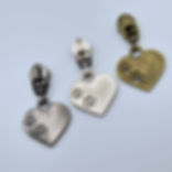 All three zipper pulls shown side by side on a white background, highlighting the finish differences.