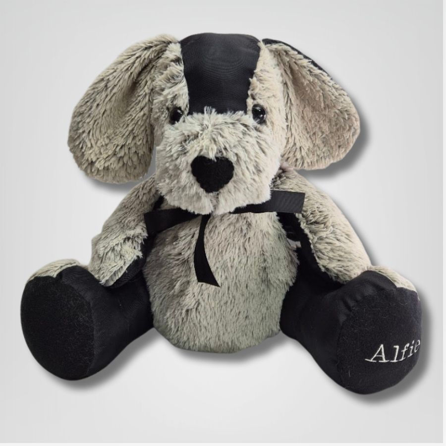 A keepsake memory dog made from soft grey fabric with darker ears and paws, featuring stitched eyes, a black nose, and the na