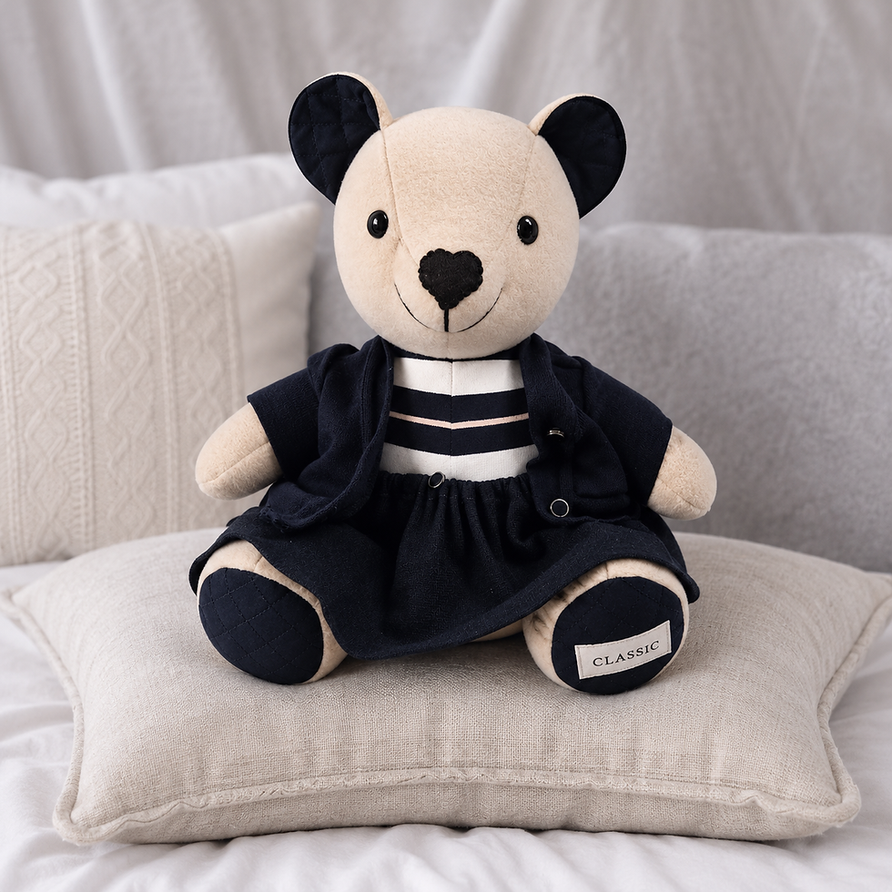 A memory bear made from a loved one's shirt by Deborah Jameson Creations, resting against a pillow