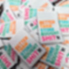 Pile woven labels with the phrase “Better Than Store Bought Shit” in orange, teal, green, and pink thread