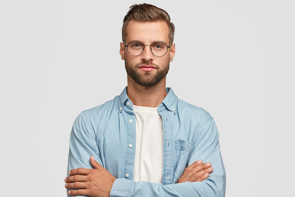 Man with beard, glasses, blue shirt, and crossed arms