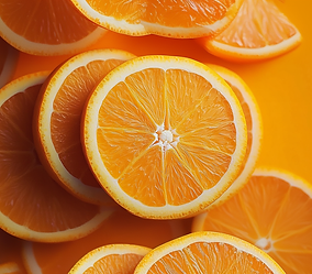 Várias fatias de laranja dispostas sobre um fundo de cor laranja vibrante.