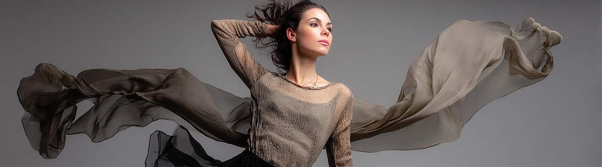 Mulher dançando suavemente. Vestida com uma blusa de manga comprida e saia preta, transparentes e texturizada.