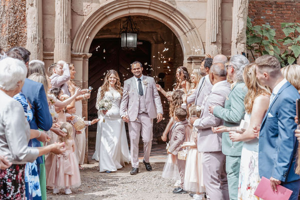 Newlyweds walk through confetti after their wedding ceremony celebrations Mo Photography