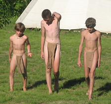 Three boys wearing breechclouts walking in the Clearing