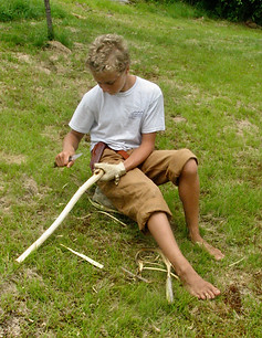 Boy carving a bow