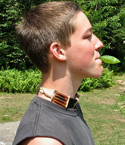 A boy blowing up a leaf