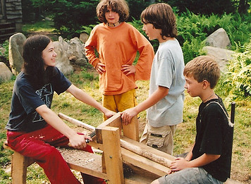 Campers use a spokeshave bench to carve a bow
