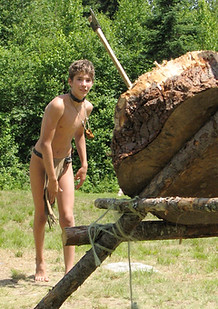 A boy throwing tomahawks at a taget
