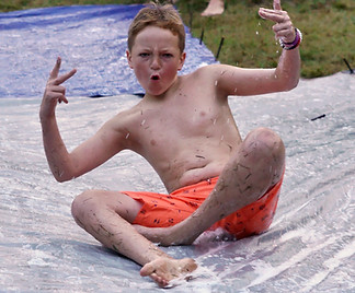 A boy sliding on a slip and slide