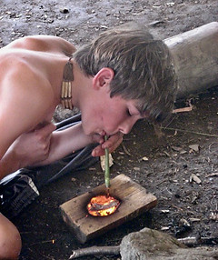 Primitive Skills Boy burning a bowl with a coal