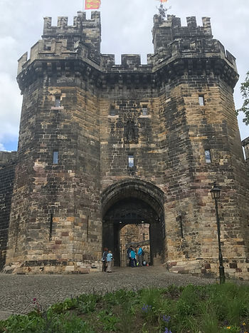 The view of the main gates are you walk up to Lancaster castle on a sunny day during a summer holiday day trip.