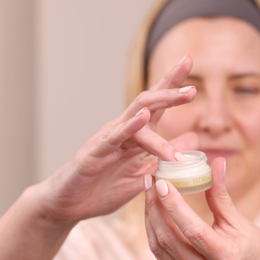 Woman applying lip balm from a small jar. Citrus Lip Balm Update - Skin by Tae