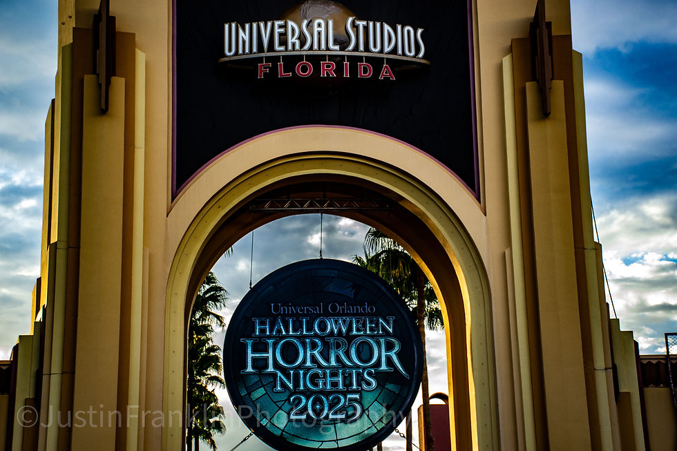 Archway at Universal Studios Florida with Halloween Horror Nights 2025 sign. Sky and palm trees in background, creating an eerie mood.