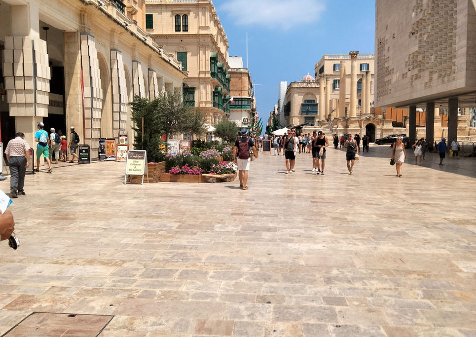 Piazza affollata con persone che camminano. Edifici e cielo blu. My Site 1