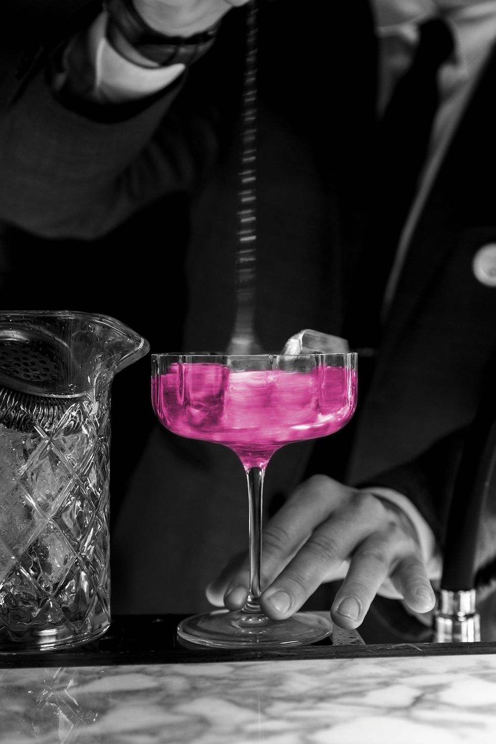 Black and white photo of bartender stirring cocktail