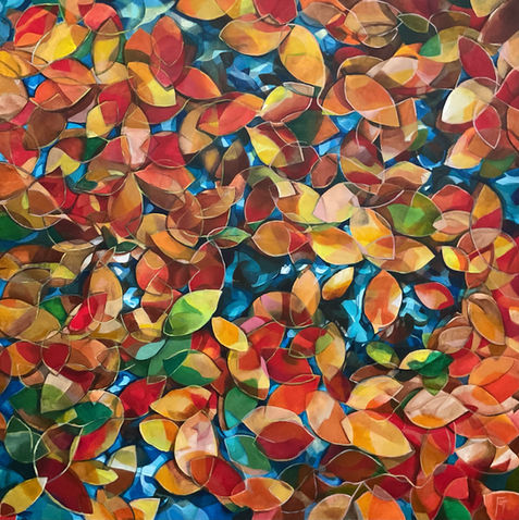 Foglie autunnali vibranti rosse, arancioni e gialle galleggianti sull'acqua blu.