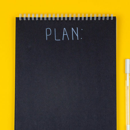 An event planner's notebook at LEMONADE in Whistler, Canada sits on a bright yellow background ready to plan a corporate retreat. 