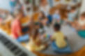Diverse group of preschool children and teachers playing musical instruments in a colorful