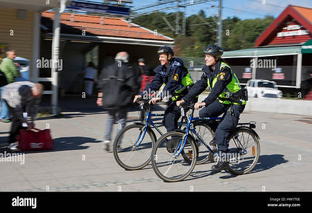 two-female-police-officers-patrolling-by-bike-in-upplands-vasby-sweden-HW1T0E.jpg
