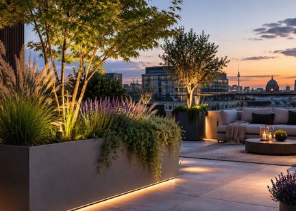 Exklusive Dachterrassengestaltung mit modernen Pflanzgefäßen, Ziergräsern, integrierter LED-Beleuchtung und elegantem Lounge-Bereich bei Sonnenuntergang über der Stadt.